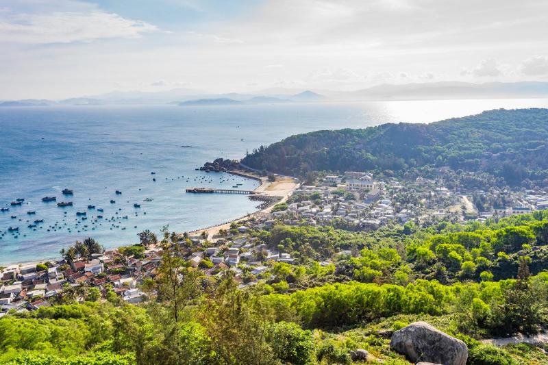 Idyllic pristine white sand beach on Binh Lap Island, Vietnam, with emerald green waters and clear blue sky.